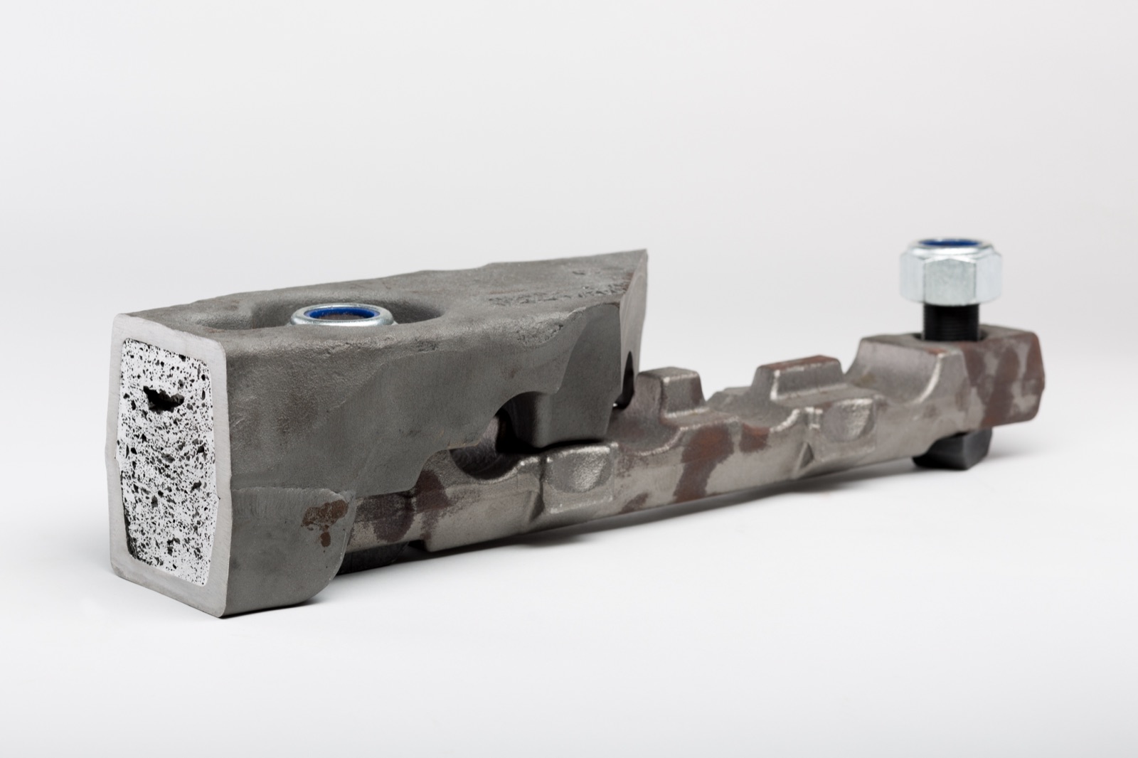 Ein Träger für den Bergbau mit angeschnittenem Ende; der Hohlraum des Profils ist mit Aluminiumschaum gefüllt. Am gegenüberliegenden Ende sitzt eine verschraubte Verbindung.