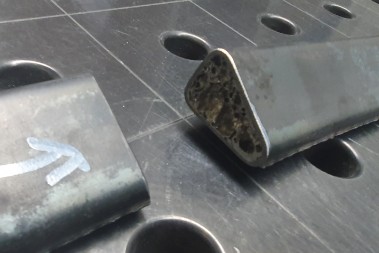 Nahaufnahme zweier Profilenden auf einem Lochraster-Tisch; im angeschnittenen Profil ist der Aluminiumschaum im Hohlraum zu sehen.