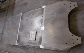 Große Grundplatte mit zwei durchgehenden Längsnähten und einer Aussparung an der Stirnseite; auf der Platte liegt eine Arbeitskarte.