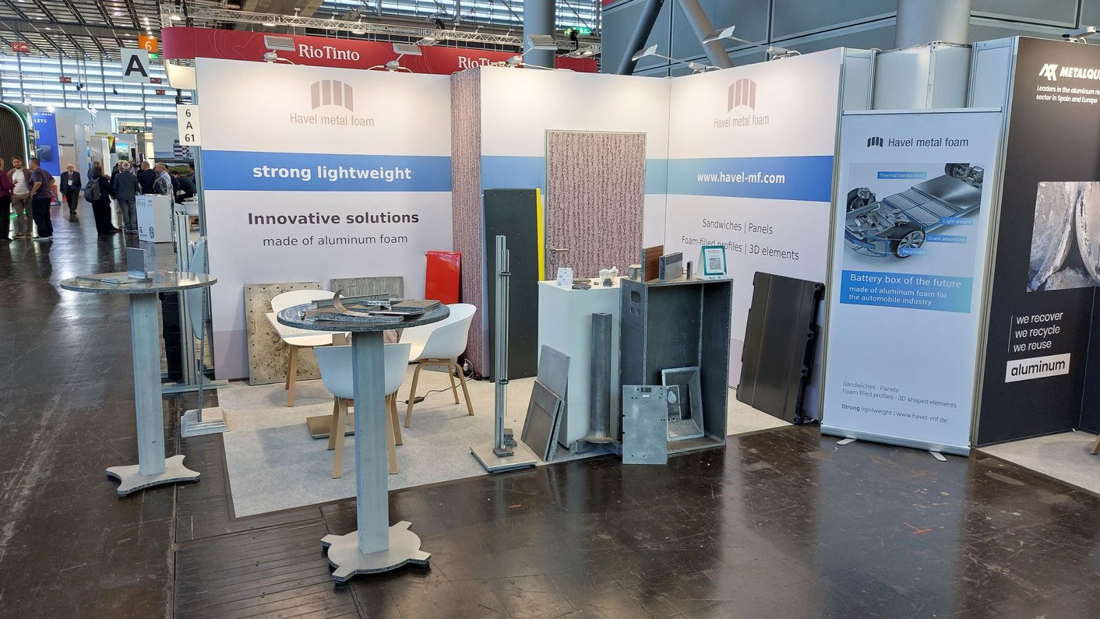 Messestand von Havel metal foam: Stehtische, Platten und ein offenes Gehäuse aus Aluminiumschaum vor weißen Wänden mit blauem Band.
